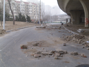万柳村大街桥下砖头瓦砾路中散落 影响通行