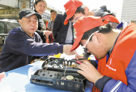 志愿者为社区居民修理电器。记者徐文杰摄