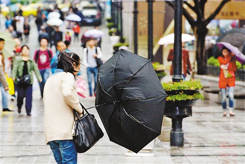 4月5日,解放碑步行街,大风刮来,吹翻了市民的雨伞.