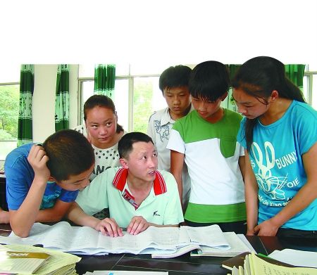 城口坪坝中学,曾良平老师为学生指导英语作业.