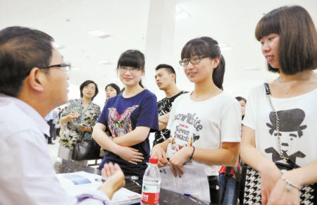 　　求职毕业生与招聘单位工作人员交谈。记者徐文杰摄