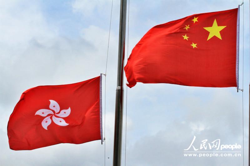 冉冉升起的五星红旗与香港区旗.