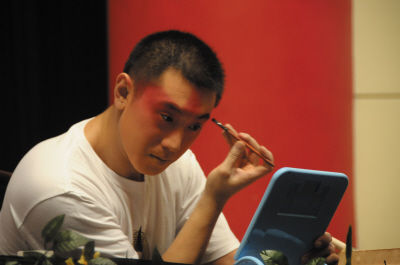 大连京剧院青年京剧演员符鹏现场为观众演示演员化妆.