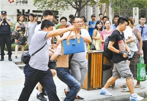 嫌疑人被警方控制,现场缴获一手拎包.