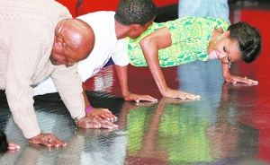 　　米歇尔从不错过推广健康生活的机会。2011年，她随丈夫造访南非期间，还和79岁的图图大主教(左）一起做俯卧撑。