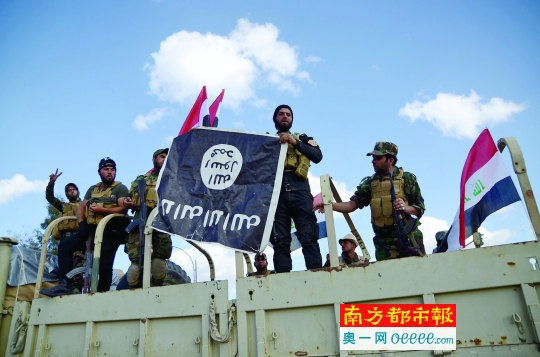 3月31日,在伊拉克提克里特,什叶派民兵展示缴获的"伊斯兰国"旗帜.