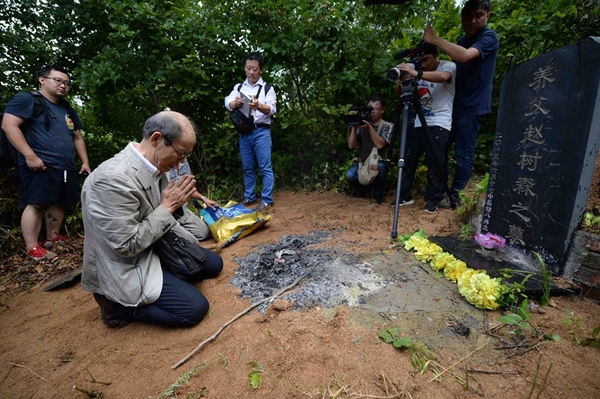 8月11日,在黑龙江省牡丹江市,中岛幼八在自己养父的墓前祭拜.