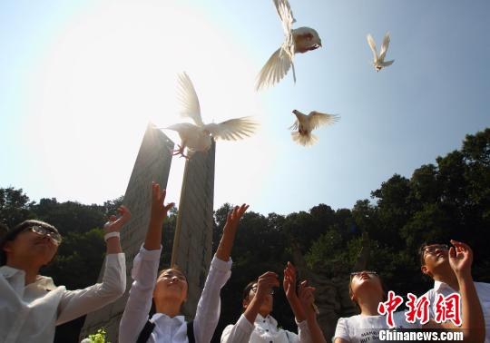 在烈士纪念碑前,孩子们放飞了象征和平的白色鸽子. 李珂 摄