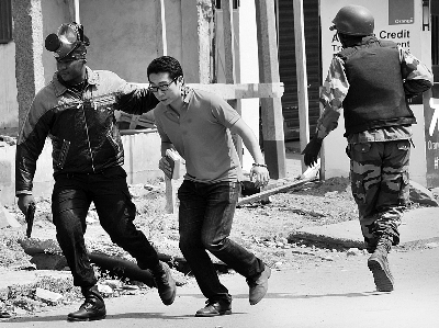 安保人员护送一名被解救出来的人质离开 图/视觉中国