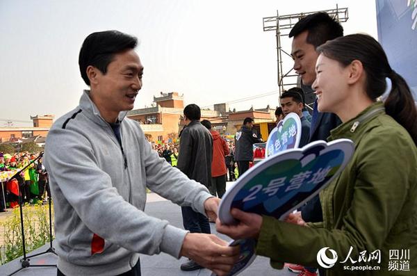 中共崇州市委书记赵浩宇(左)为露营俱乐部代表赠送营地"钥匙".