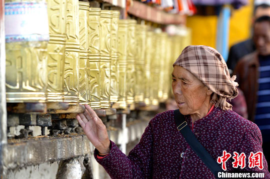 3月14日,正在八廓街内转经的藏族老阿妈.李林 摄