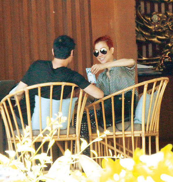 郑秀文和老公许志安坐在竹椅上喝茶休息,享受着泰国温暖的阳光.