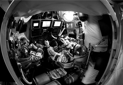 神舟九号航天员乘组景海鹏(中),刘旺(右),刘洋(左)在模拟返回舱进行