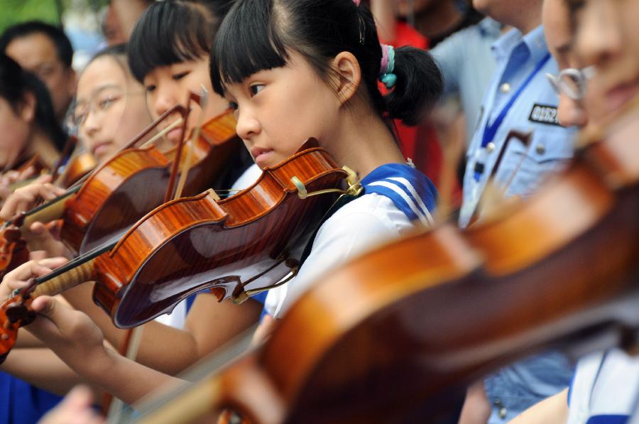 6月10日,学生们在开幕式上演奏小提琴.新华社记者王凯摄